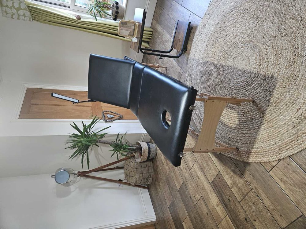 The treatment room at Glebe Farm, with a treatment couch, a lamp and a mirror